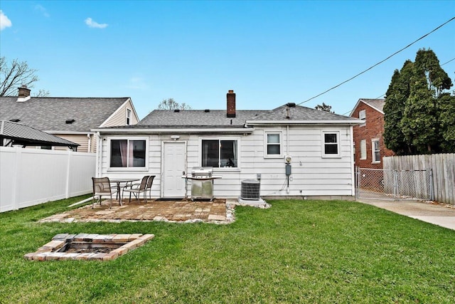 back of property with cooling unit and a yard