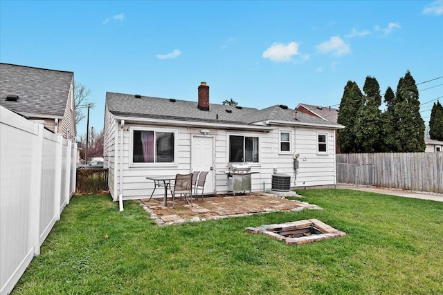 rear view of house featuring cooling unit and a yard