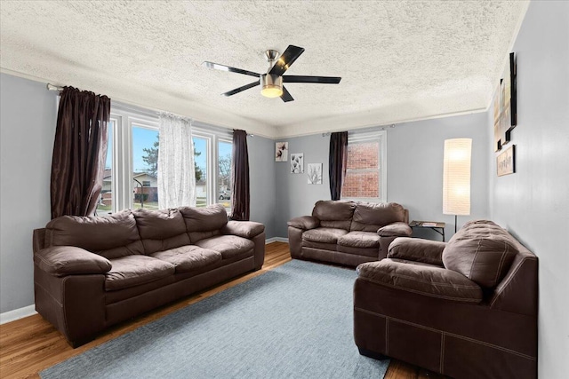 living room with hardwood / wood-style flooring, ceiling fan, plenty of natural light, and a textured ceiling