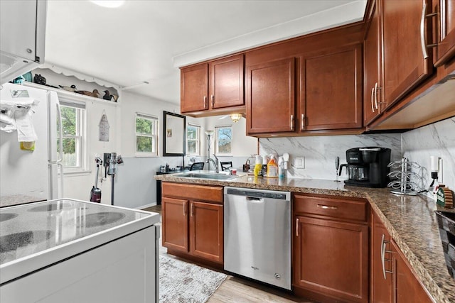 kitchen featuring white appliances, stone countertops, sink, and decorative backsplash