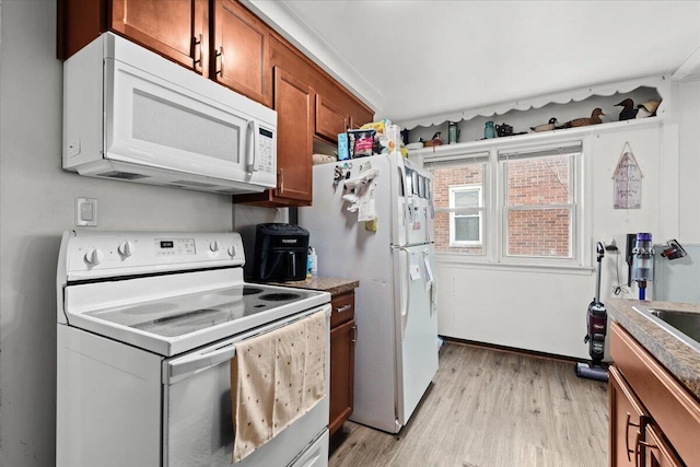 kitchen with white appliances and light hardwood / wood-style floors