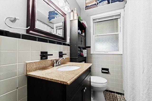 bathroom featuring tile walls, vanity, and toilet