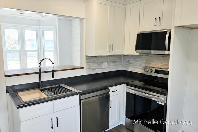 kitchen with white cabinetry, appliances with stainless steel finishes, sink, and backsplash