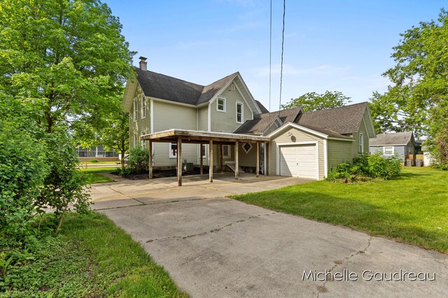 front facade with a carport, a garage, and a front lawn