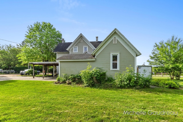 rear view of house with a carport and a lawn