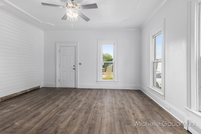 empty room with dark wood-type flooring, ceiling fan, and crown molding