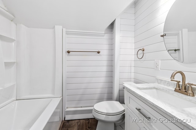 full bathroom with hardwood / wood-style flooring, tub / shower combination, wooden walls, vanity, and toilet