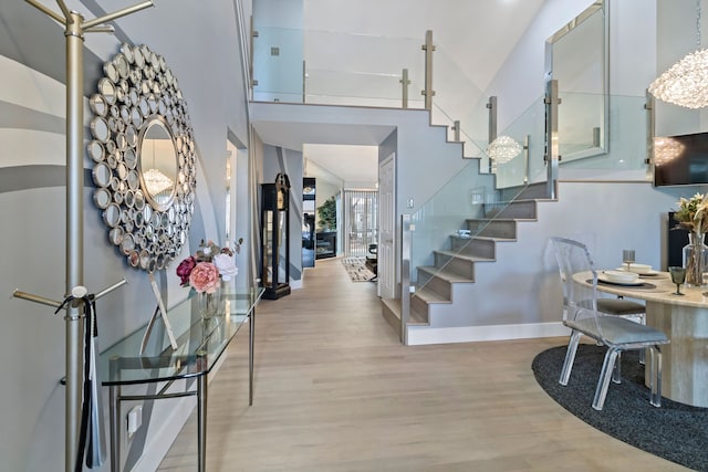 foyer entrance featuring a towering ceiling and light hardwood / wood-style floors