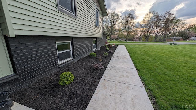 property exterior at dusk featuring a yard