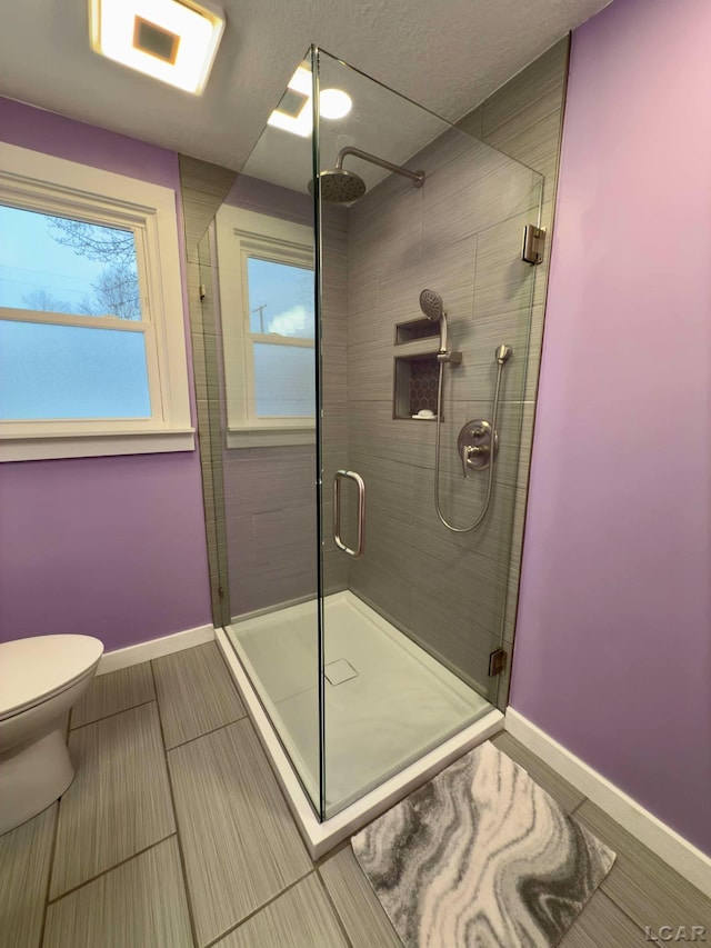 bathroom featuring toilet and an enclosed shower