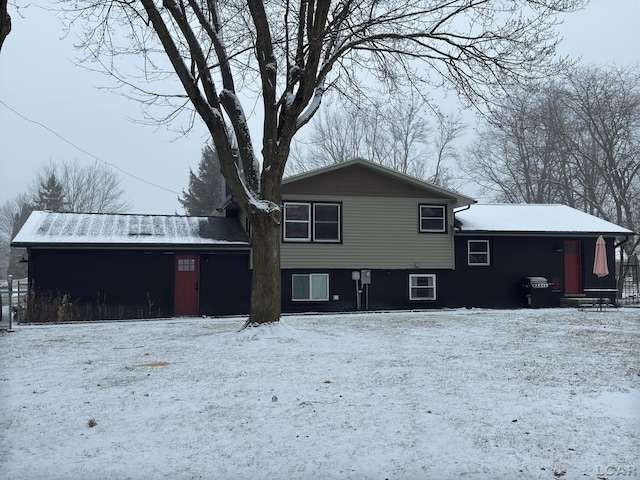 view of snow covered back of property