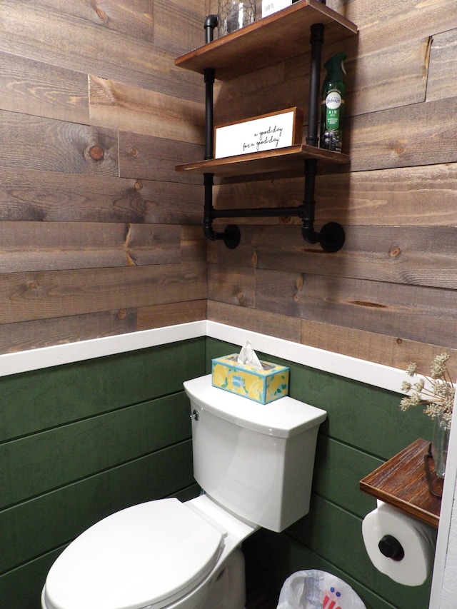 bathroom featuring toilet and wood walls