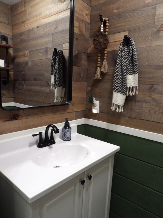 bathroom with vanity and wood walls