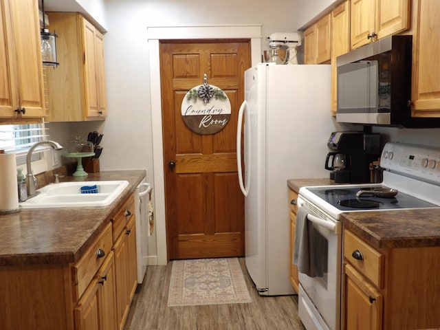 kitchen featuring white appliances, sink, and light hardwood / wood-style flooring