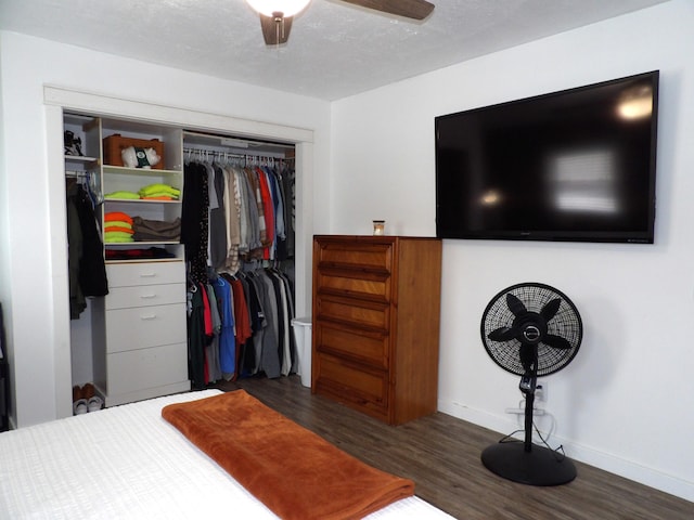 bedroom featuring ceiling fan, dark hardwood / wood-style floors, a closet, and a textured ceiling