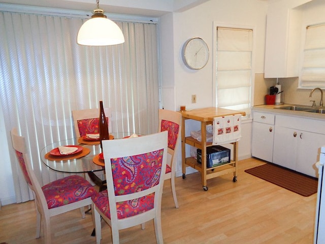 dining area with sink and light hardwood / wood-style floors