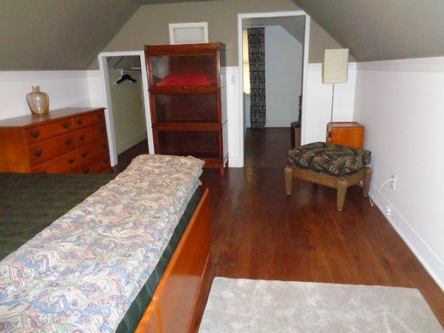 bedroom with dark wood-type flooring and lofted ceiling