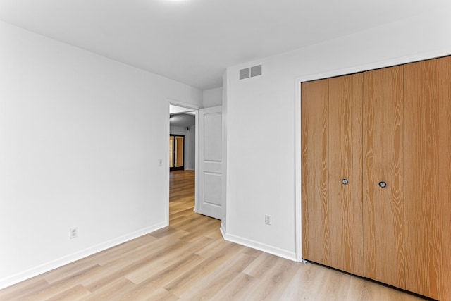 unfurnished bedroom featuring a closet and light hardwood / wood-style flooring