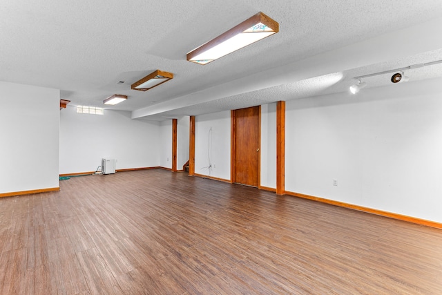 basement featuring hardwood / wood-style floors and a textured ceiling