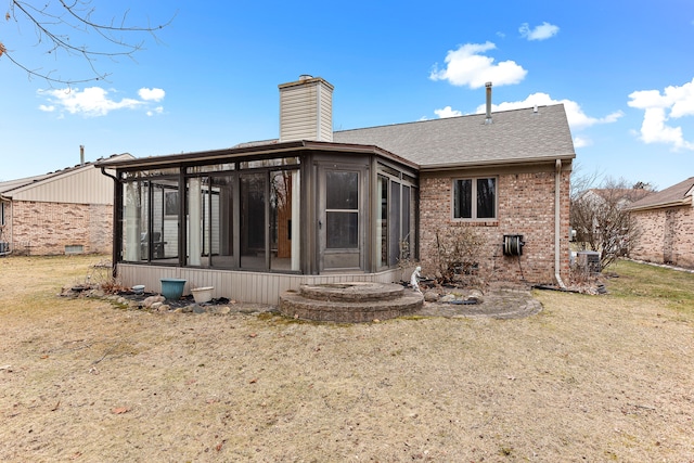 back of house with a sunroom and a yard