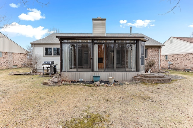 rear view of property with a sunroom and a lawn