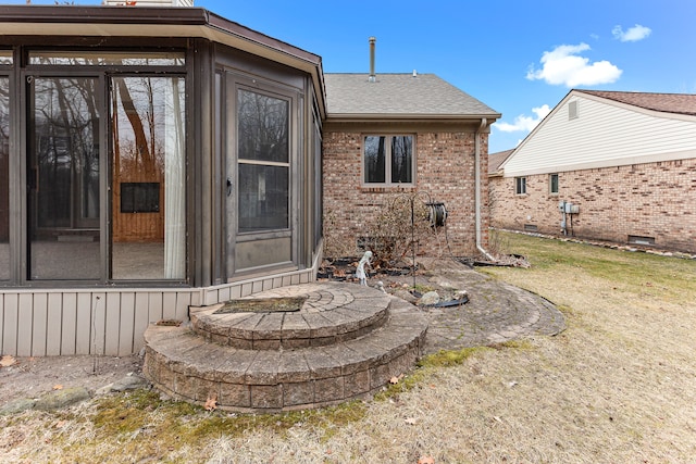 back of house featuring a sunroom and a lawn