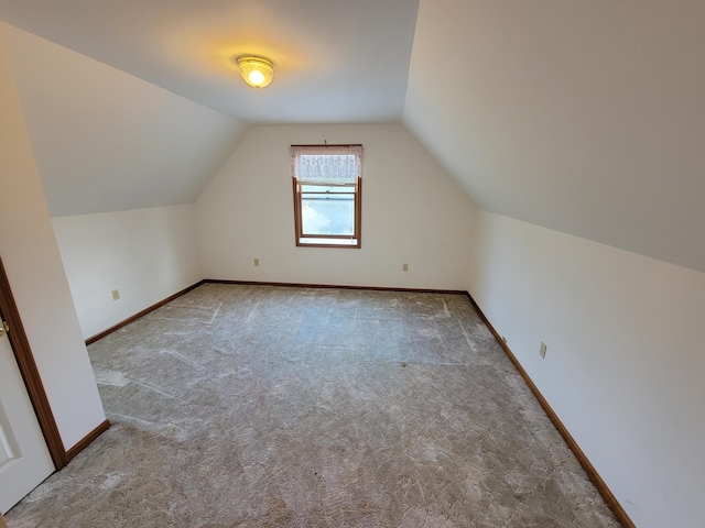 bonus room featuring vaulted ceiling and carpet