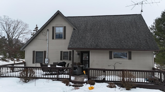 snow covered rear of property featuring a wooden deck