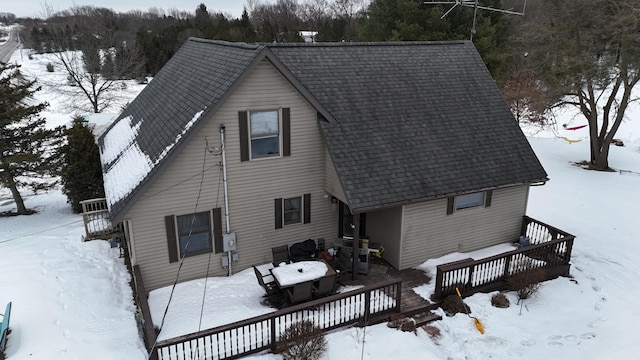 view of snow covered back of property