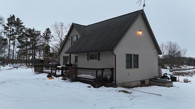 snow covered rear of property featuring a deck