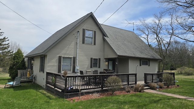 rear view of house with a yard, a deck, and a shingled roof