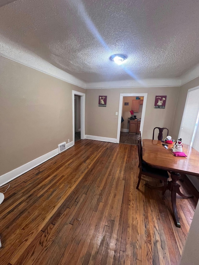 dining area featuring dark hardwood / wood-style floors and a textured ceiling