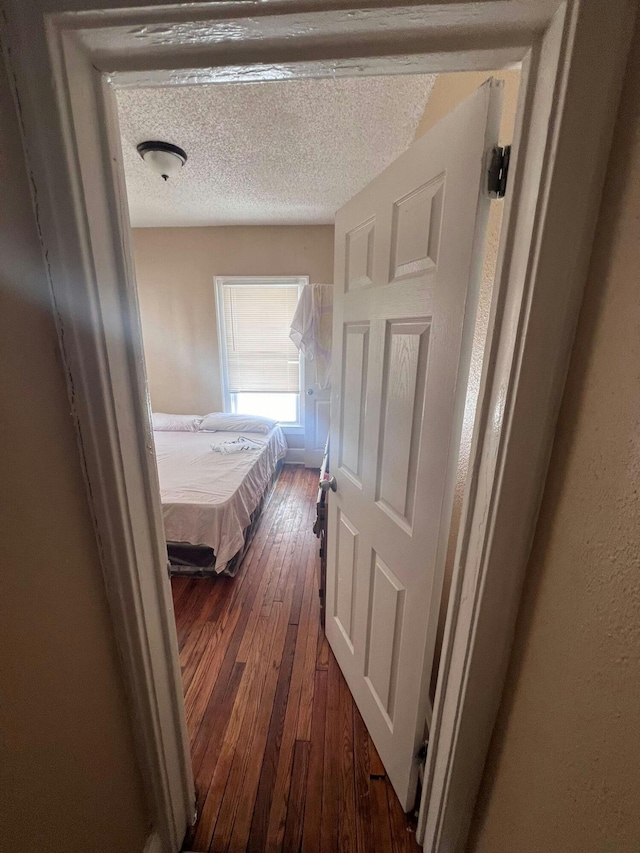 bedroom with dark wood-type flooring and a textured ceiling