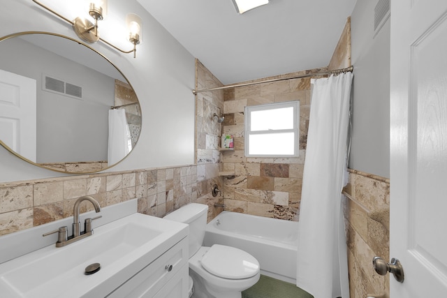 full bathroom with vanity, toilet, tile walls, and shower / bath combo