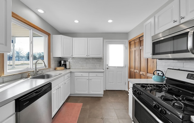 kitchen with white cabinetry, stainless steel appliances, sink, and a wealth of natural light