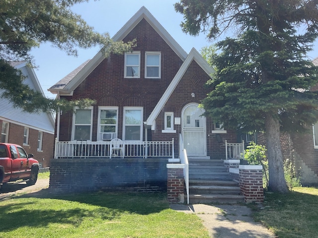 view of front of house with covered porch and a front lawn