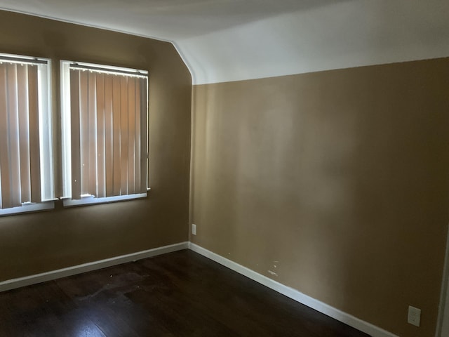 additional living space featuring lofted ceiling and dark wood-type flooring