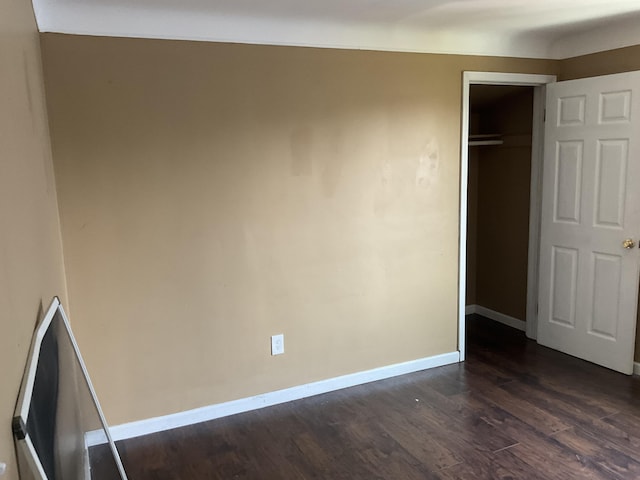 unfurnished bedroom featuring dark hardwood / wood-style flooring and a closet