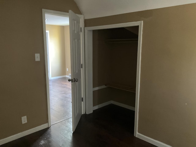 interior space with vaulted ceiling and dark hardwood / wood-style floors