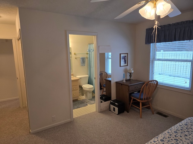 bedroom with ceiling fan, connected bathroom, and carpet