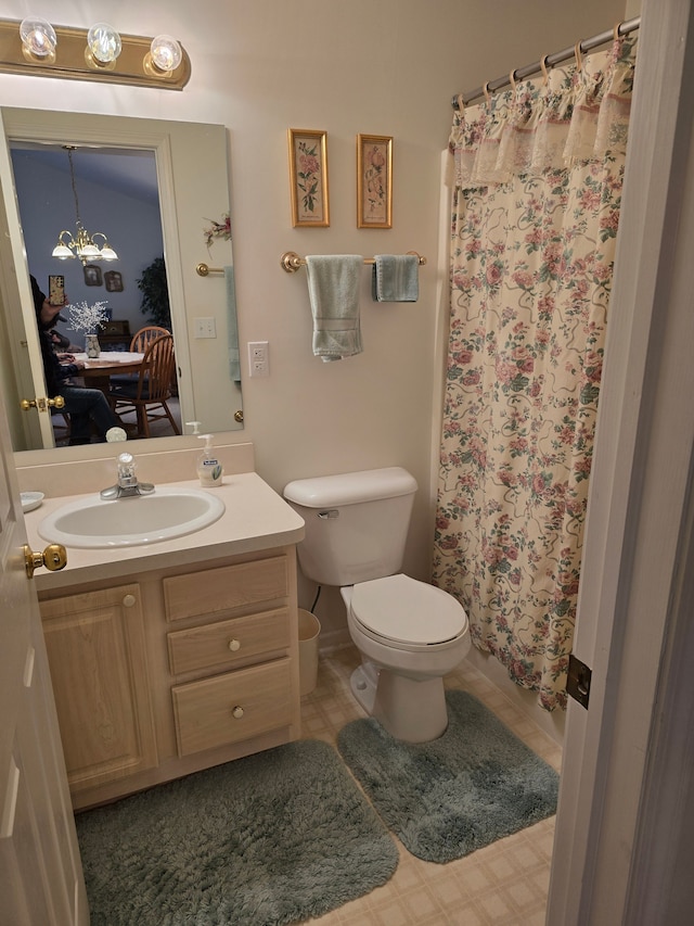 bathroom featuring vanity, a shower with shower curtain, an inviting chandelier, and toilet