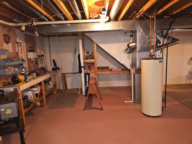 basement featuring gas water heater, brick wall, and a workshop area