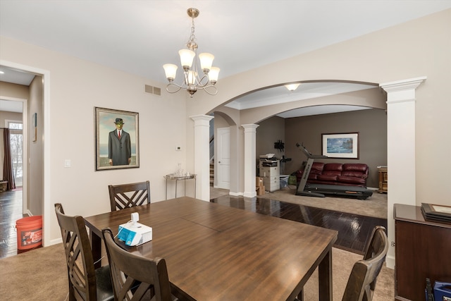 dining area featuring a notable chandelier, light wood-type flooring, and ornate columns