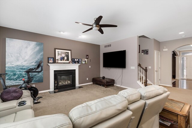 carpeted living room with ceiling fan