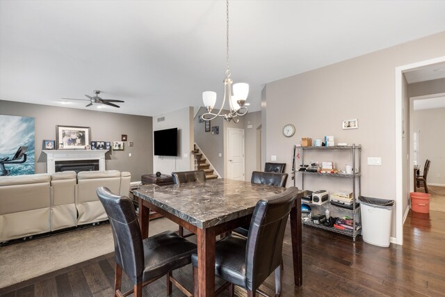 dining space with dark hardwood / wood-style floors and ceiling fan with notable chandelier