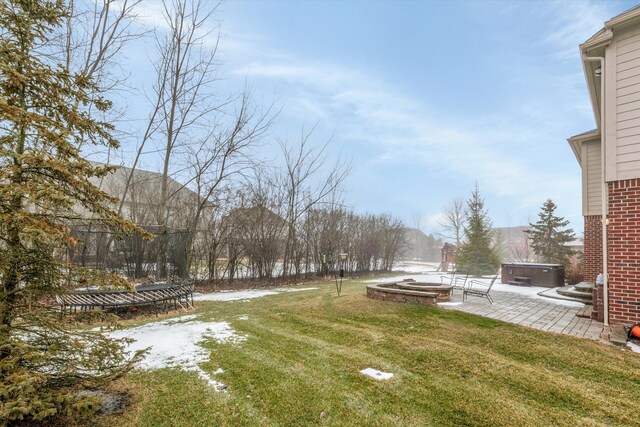 view of yard featuring a patio, a hot tub, and a trampoline