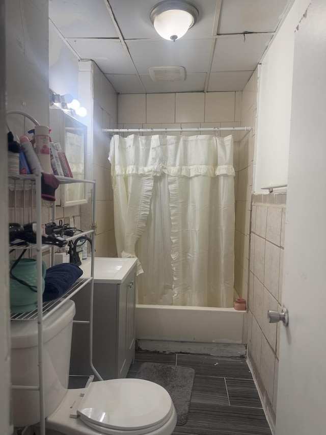 full bathroom featuring sink, tile walls, shower / tub combo, and toilet