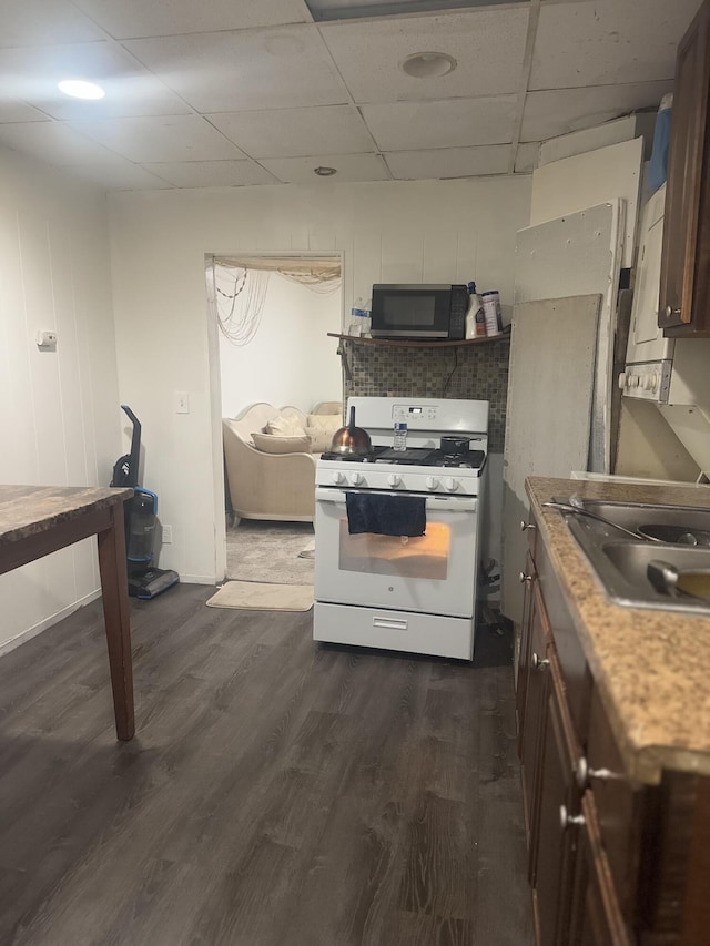 kitchen featuring dark wood-type flooring, sink, dark brown cabinets, white gas range oven, and a drop ceiling