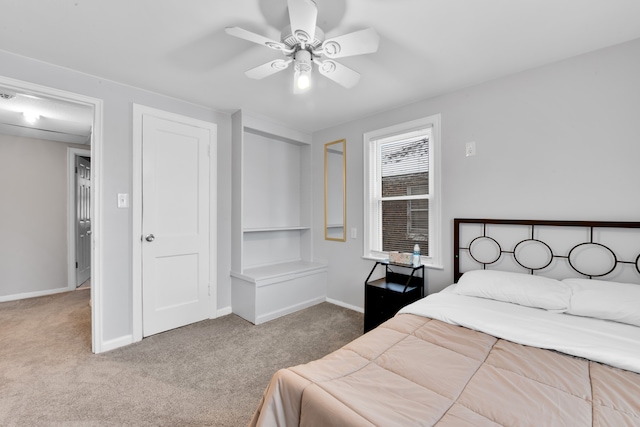 carpeted bedroom with a ceiling fan and baseboards