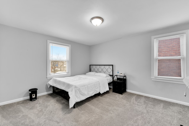 bedroom featuring light carpet and baseboards